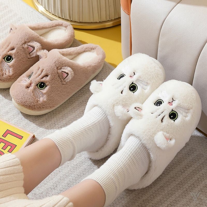 Pair of cartoon cat slippers on a person's feet with a cozy indoor background.